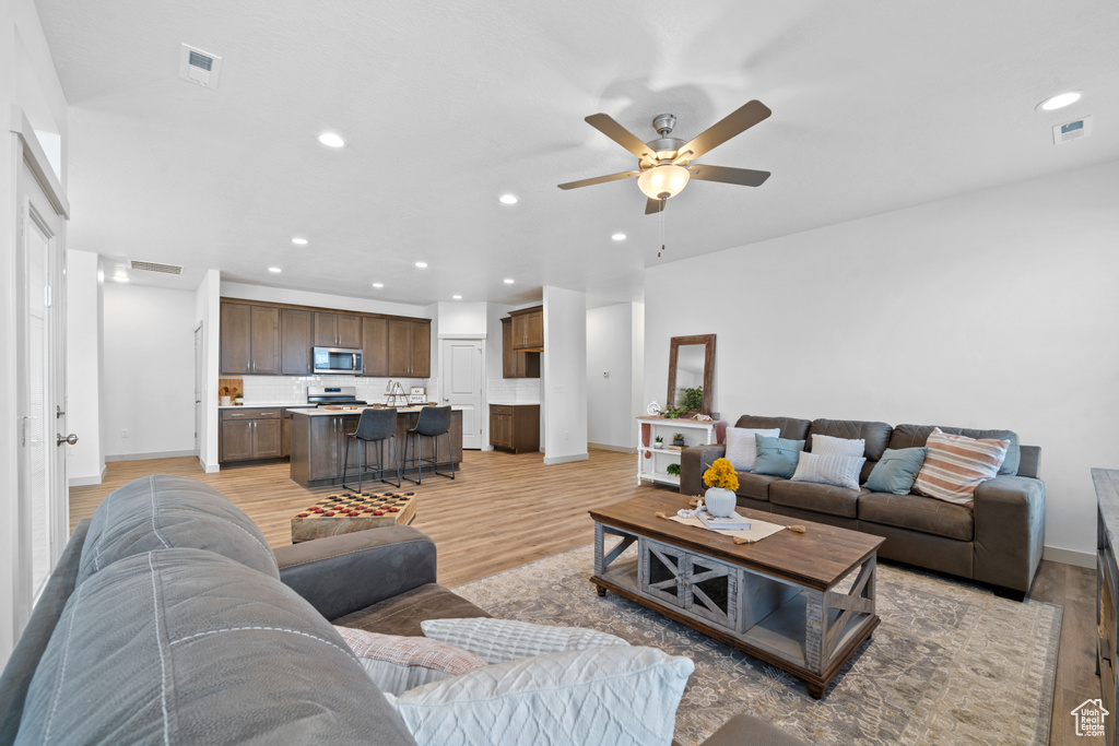 Living room featuring ceiling fan and light hardwood / wood-style flooring