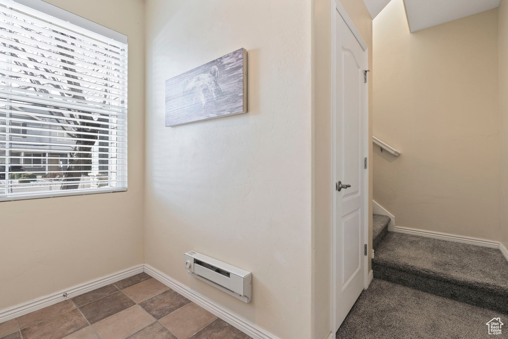 Interior space featuring dark tile floors and a baseboard radiator
