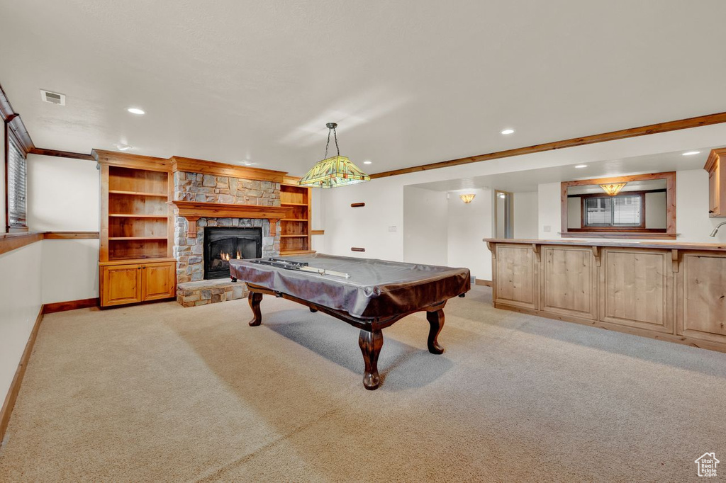 Recreation room featuring light carpet, billiards, ornamental molding, and a fireplace