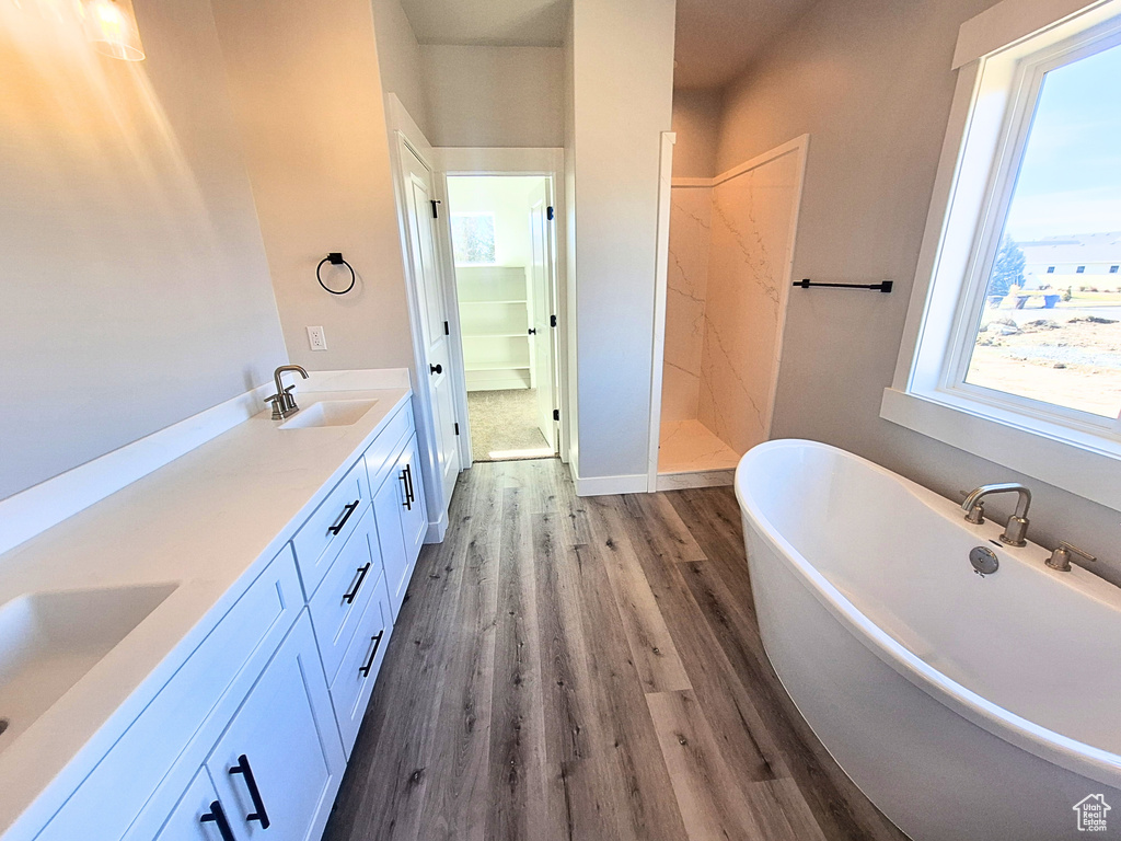 Bathroom featuring independent shower and bath, dual bowl vanity, and hardwood / wood-style flooring