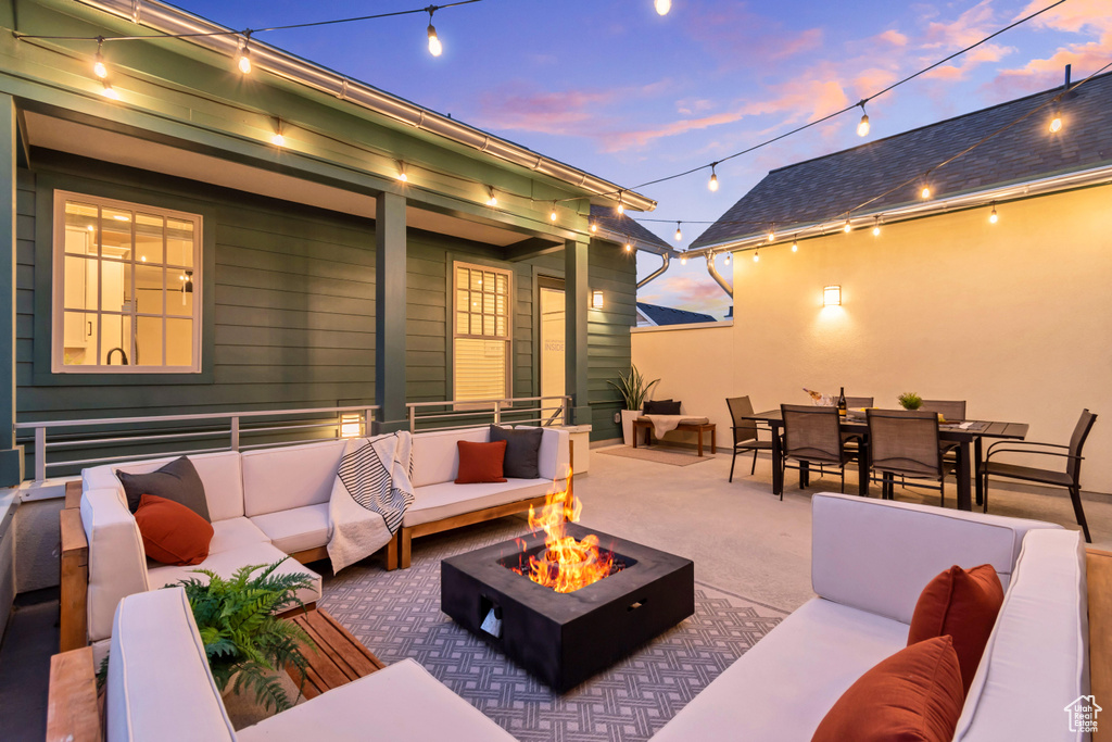 Patio terrace at dusk with an outdoor living space with a fire pit