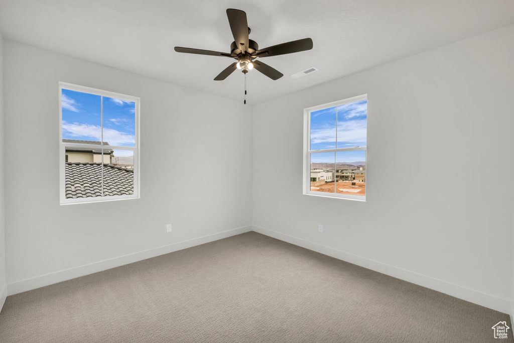 Empty room with light carpet and ceiling fan