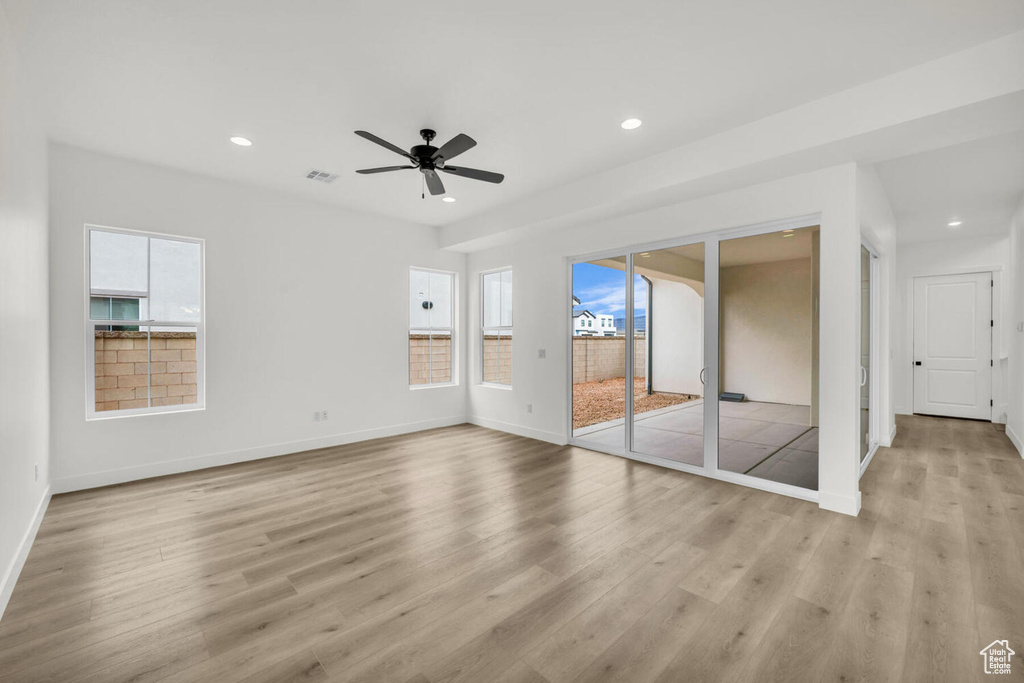Unfurnished room with ceiling fan, a wealth of natural light, and light wood-type flooring