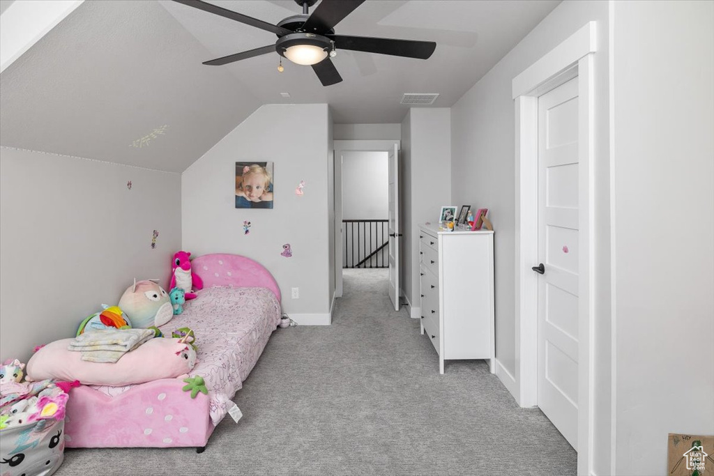 Bedroom with lofted ceiling, light colored carpet, and ceiling fan