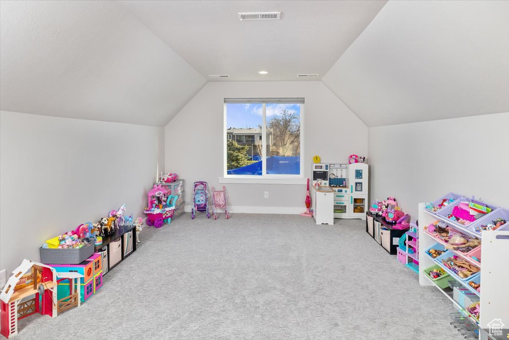 Rec room featuring vaulted ceiling and light colored carpet