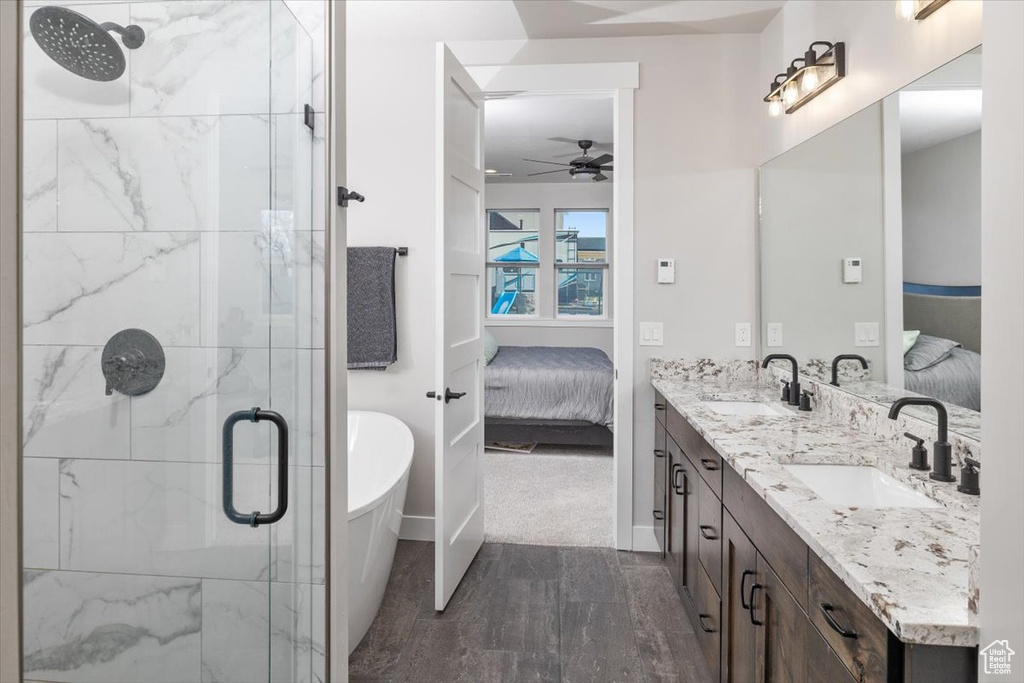 Bathroom featuring an enclosed shower, dual sinks, ceiling fan, and large vanity
