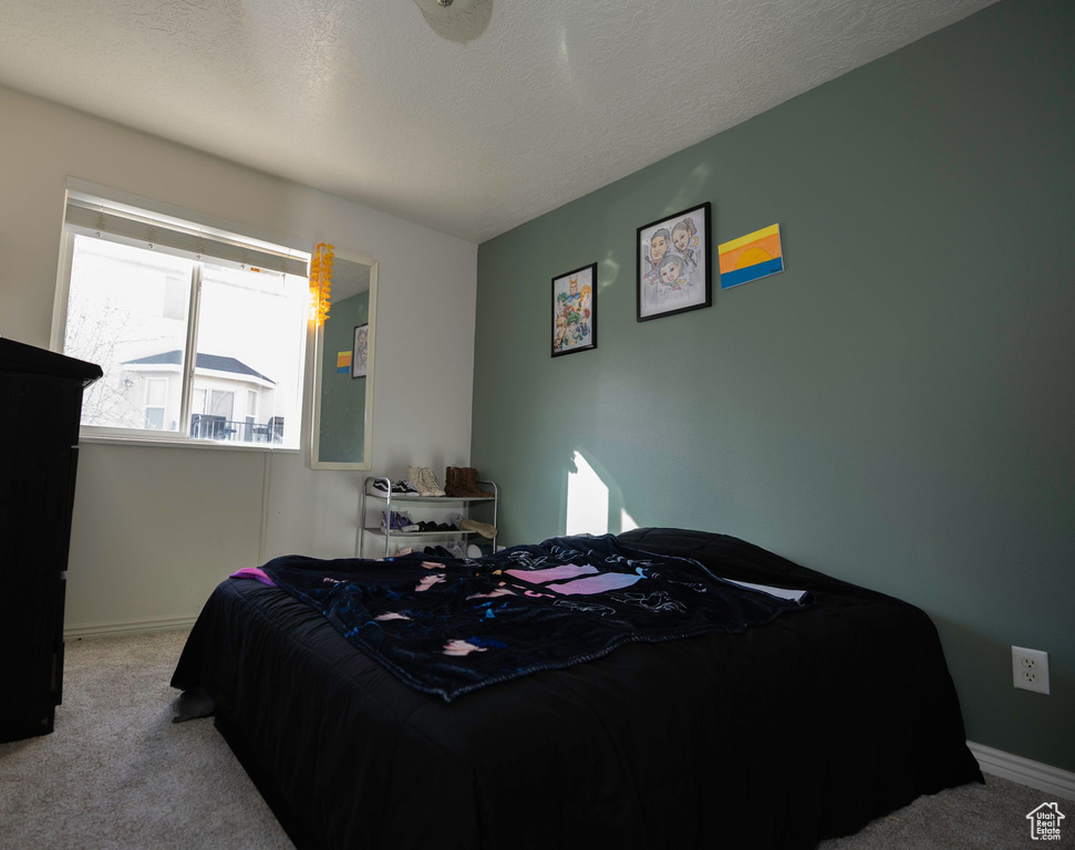 Carpeted bedroom with a textured ceiling