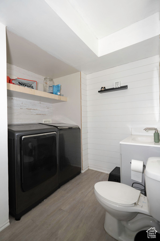 Interior space featuring vanity, toilet, washer and dryer, and hardwood / wood-style flooring