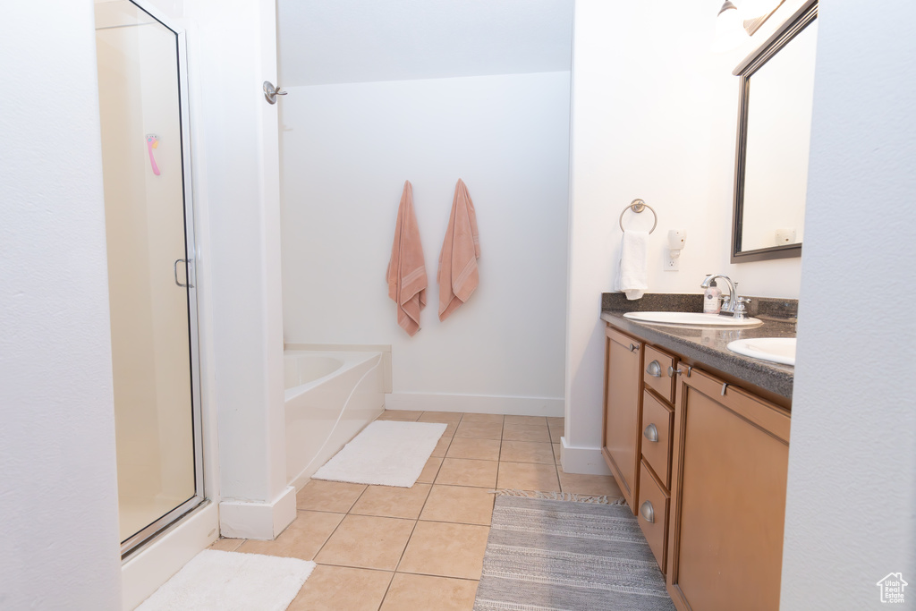 Bathroom featuring oversized vanity, independent shower and bath, double sink, and tile flooring