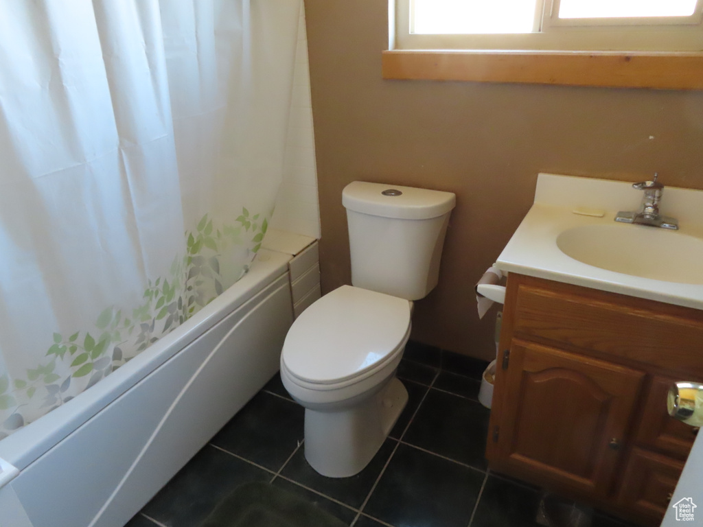 Full bathroom featuring shower / bath combo with shower curtain, toilet, tile floors, and vanity