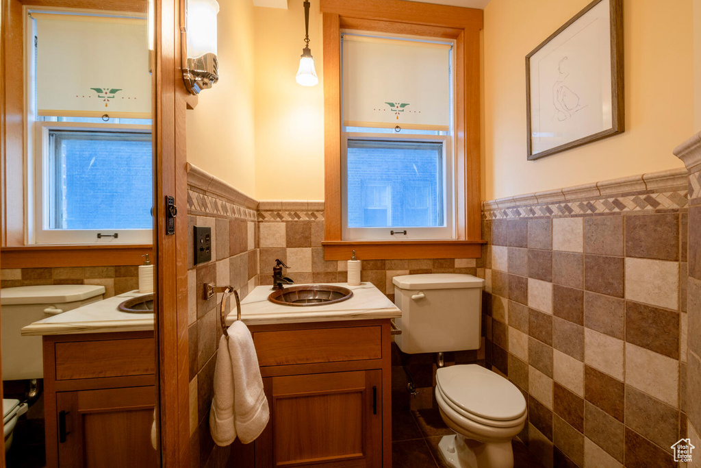 Bathroom with tile walls, backsplash, oversized vanity, tile floors, and toilet