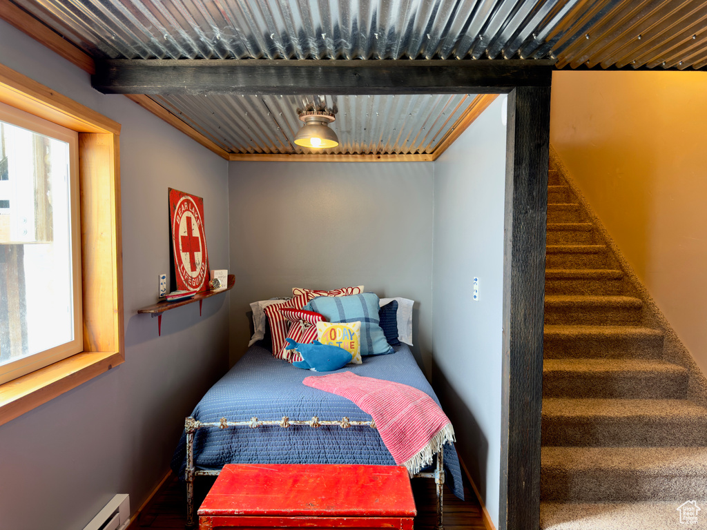 Bedroom featuring dark wood-type flooring and baseboard heating