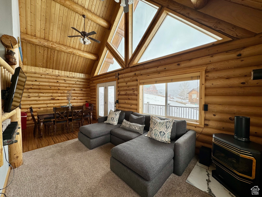 Living room with high vaulted ceiling, log walls, hardwood / wood-style floors, and beamed ceiling
