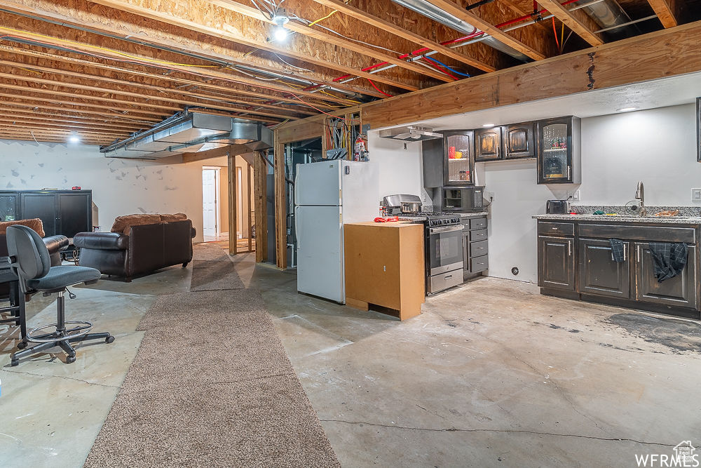Basement with sink and white refrigerator