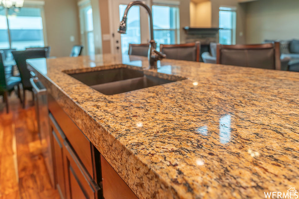 Kitchen featuring sink, dark hardwood / wood-style flooring, a healthy amount of sunlight, and light stone countertops