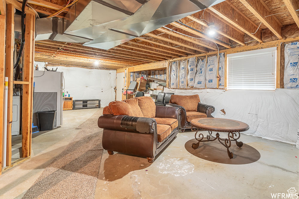 Basement with washer / clothes dryer and stainless steel fridge