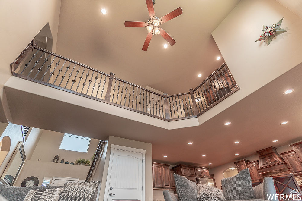 Stairs featuring a towering ceiling and ceiling fan