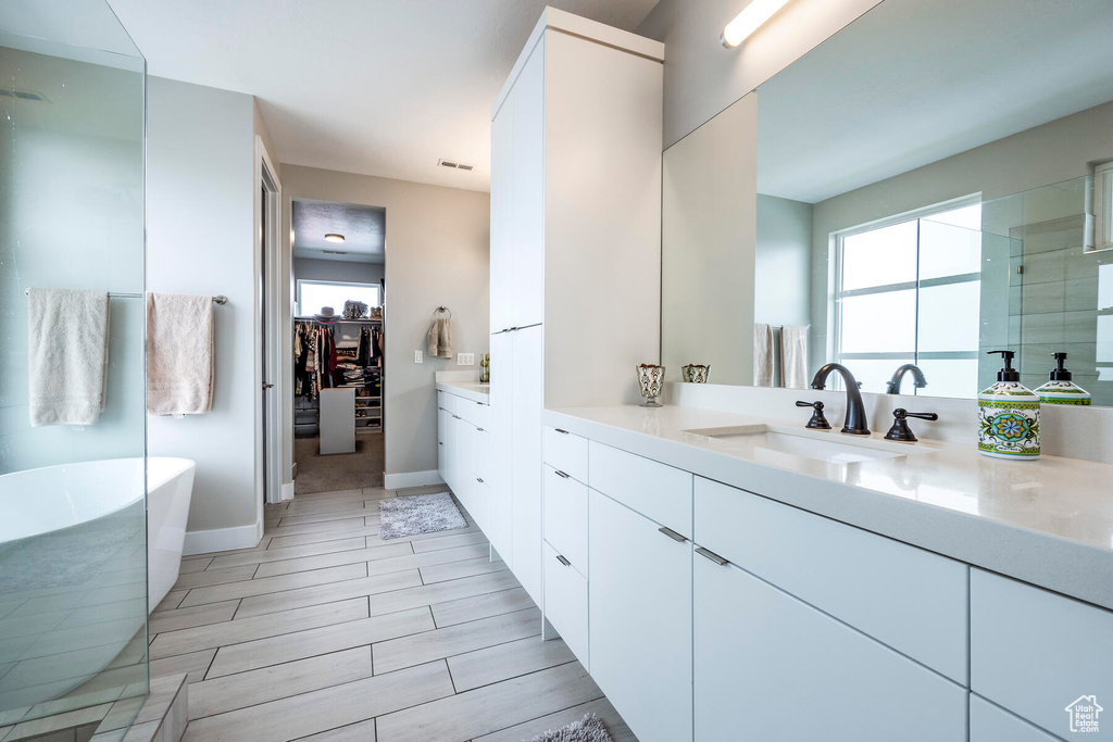 Bathroom featuring vanity, tile floors, and a bathing tub