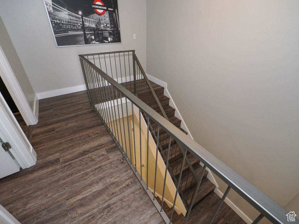 Stairs with dark hardwood / wood-style floors