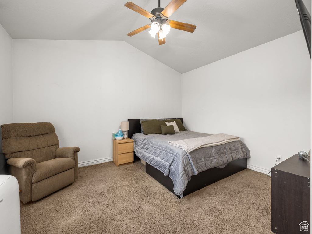 Bedroom featuring ceiling fan, vaulted ceiling, and light colored carpet