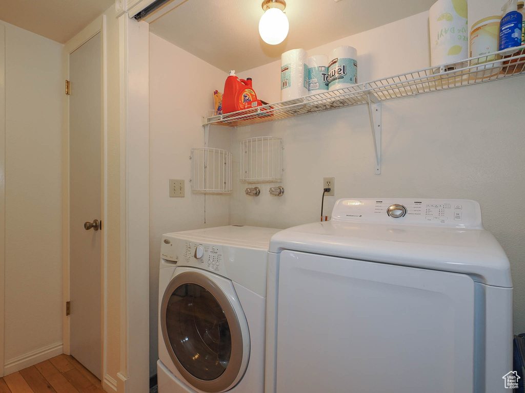 Laundry room featuring separate washer and dryer and light wood-type flooring