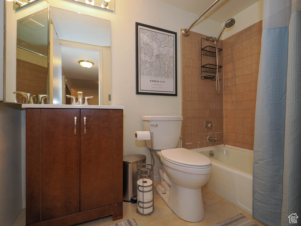 Full bathroom with shower / bath combo with shower curtain, toilet, tile floors, and vanity