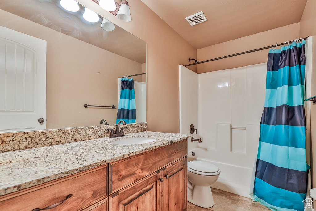 Full bathroom with toilet, shower / tub combo, vanity, and tile flooring