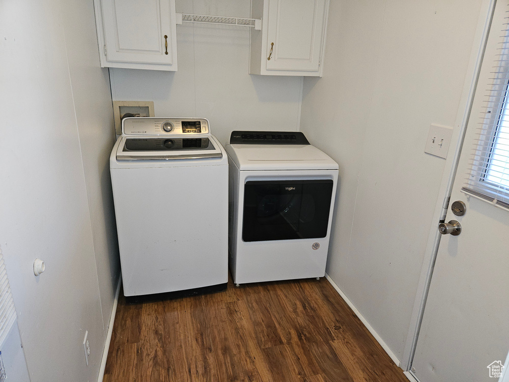 Washroom featuring washer hookup, cabinets, independent washer and dryer, and dark hardwood / wood-style floors