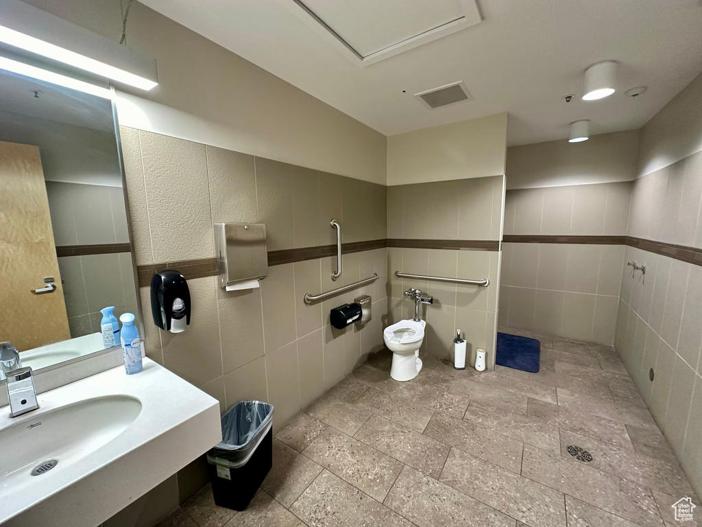 Bathroom with tile walls, tile floors, a bidet, and sink