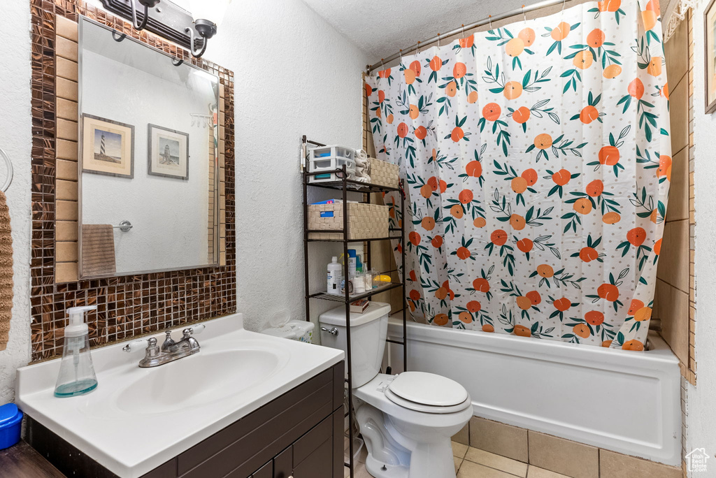 Full bathroom with shower / bath combo, toilet, tasteful backsplash, a textured ceiling, and vanity