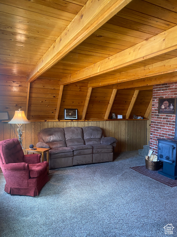 Living room with wooden ceiling, carpet flooring, a wood stove, and beamed ceiling