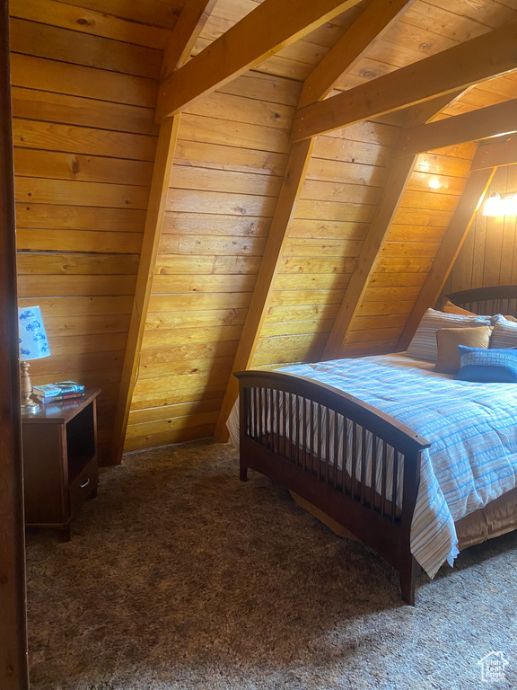 Bedroom featuring lofted ceiling with beams, wood ceiling, wooden walls, and dark carpet