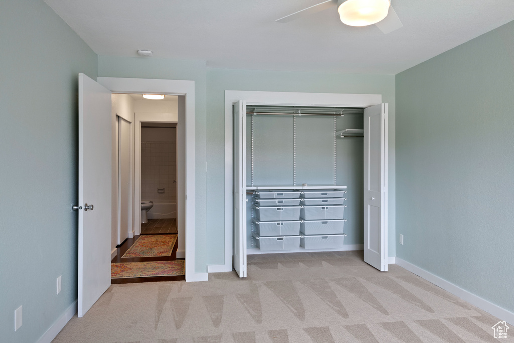 Unfurnished bedroom with a closet, light colored carpet, and ceiling fan
