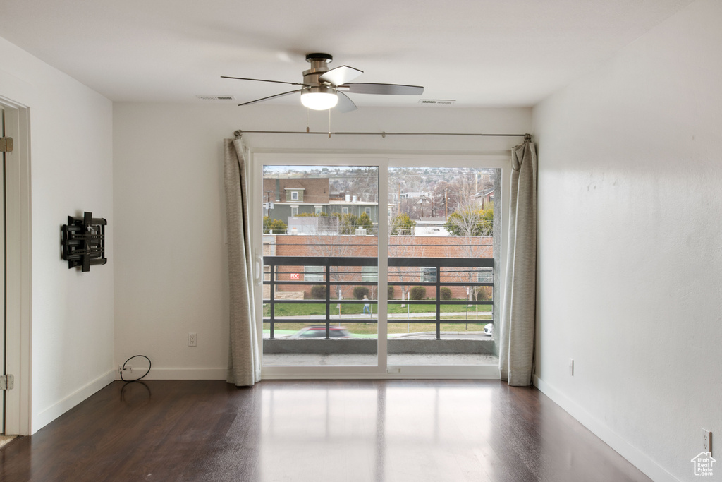 Unfurnished room with ceiling fan and dark hardwood / wood-style floors