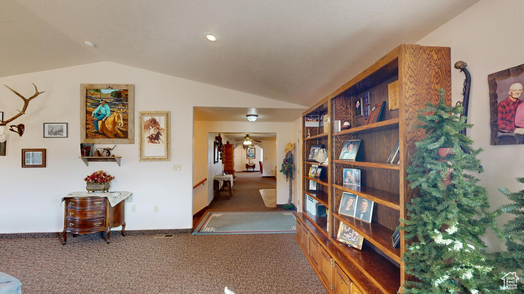 Interior space with vaulted ceiling and dark colored carpet