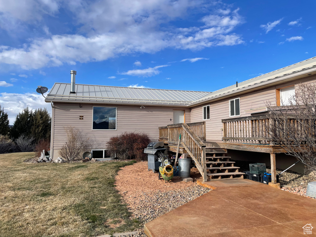 Rear view of property with a deck and a yard