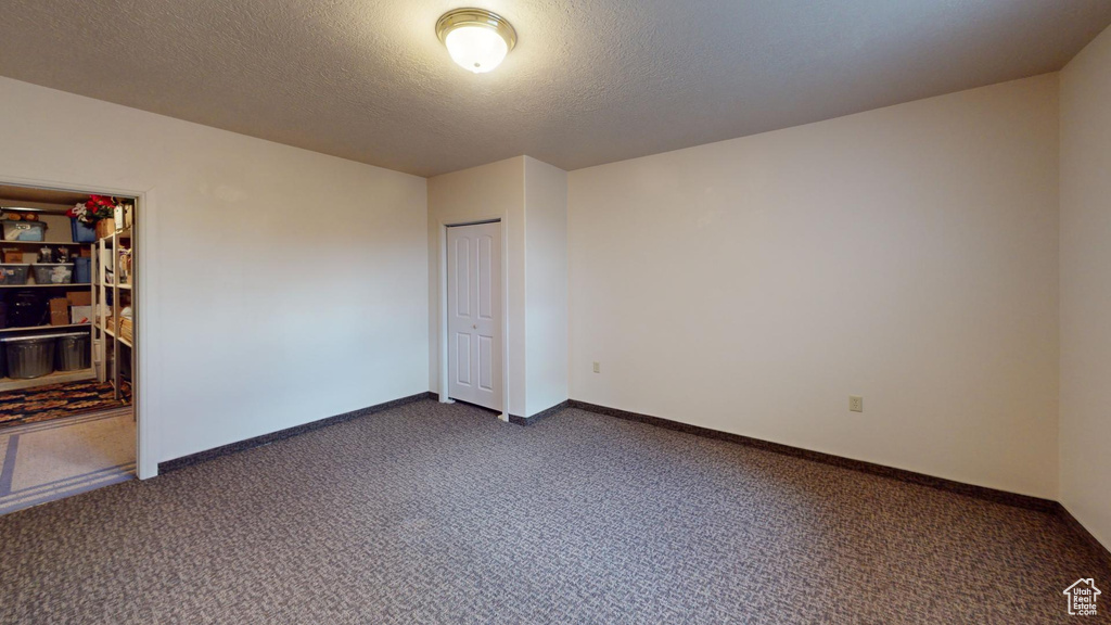 Carpeted spare room with a textured ceiling