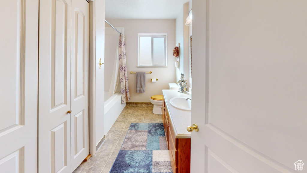 Full bathroom with shower / bath combination with curtain, toilet, vanity, and tile flooring