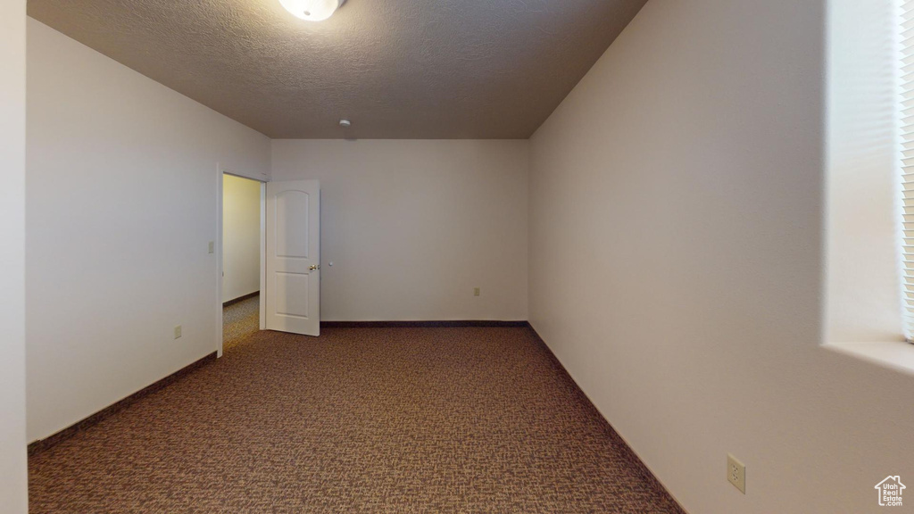 Carpeted spare room with a textured ceiling