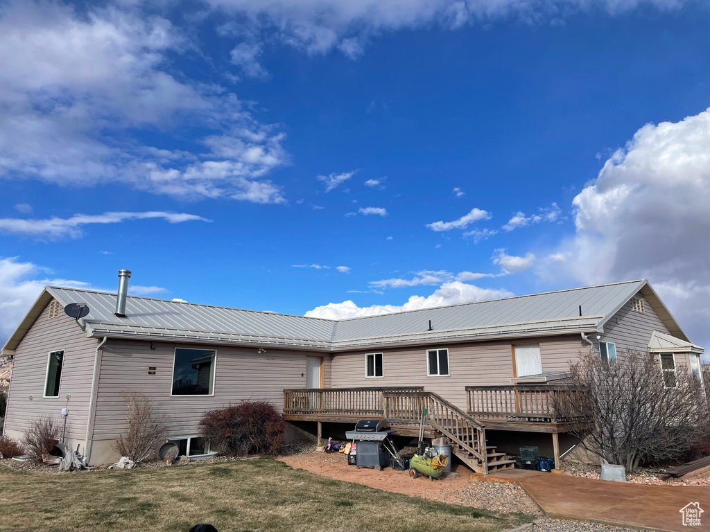 Back of house featuring a wooden deck and a yard