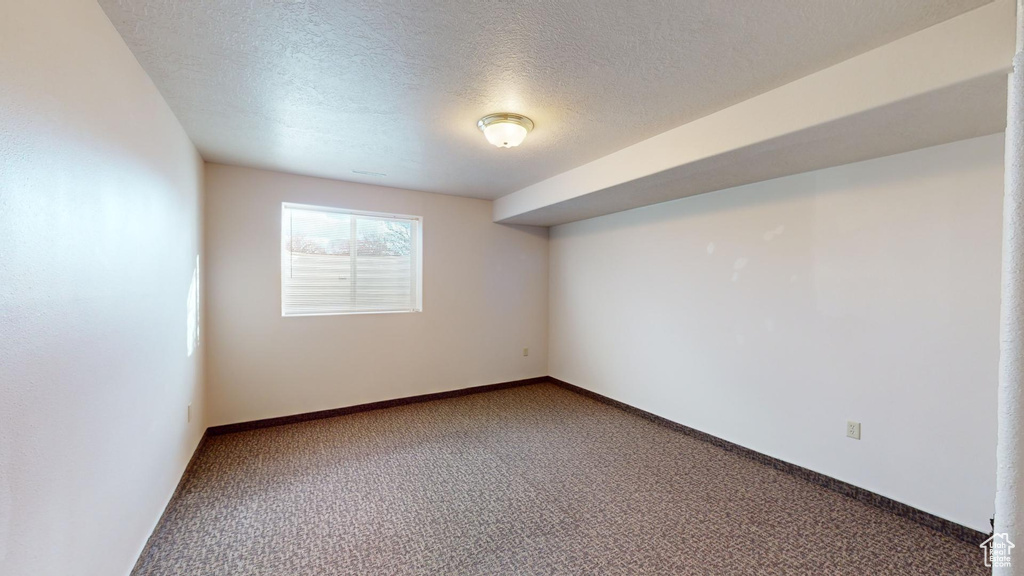 Carpeted spare room featuring a textured ceiling