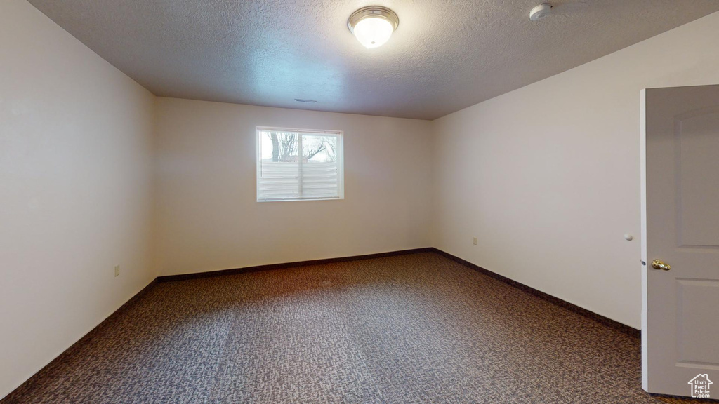 Carpeted empty room with a textured ceiling