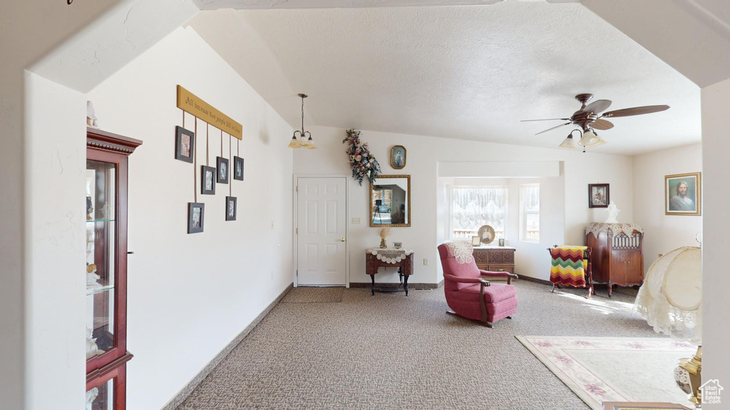 Sitting room with light carpet, a textured ceiling, ceiling fan, and lofted ceiling