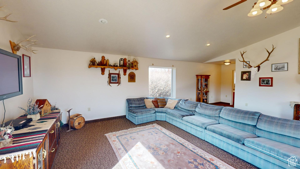 Living room featuring dark carpet and ceiling fan