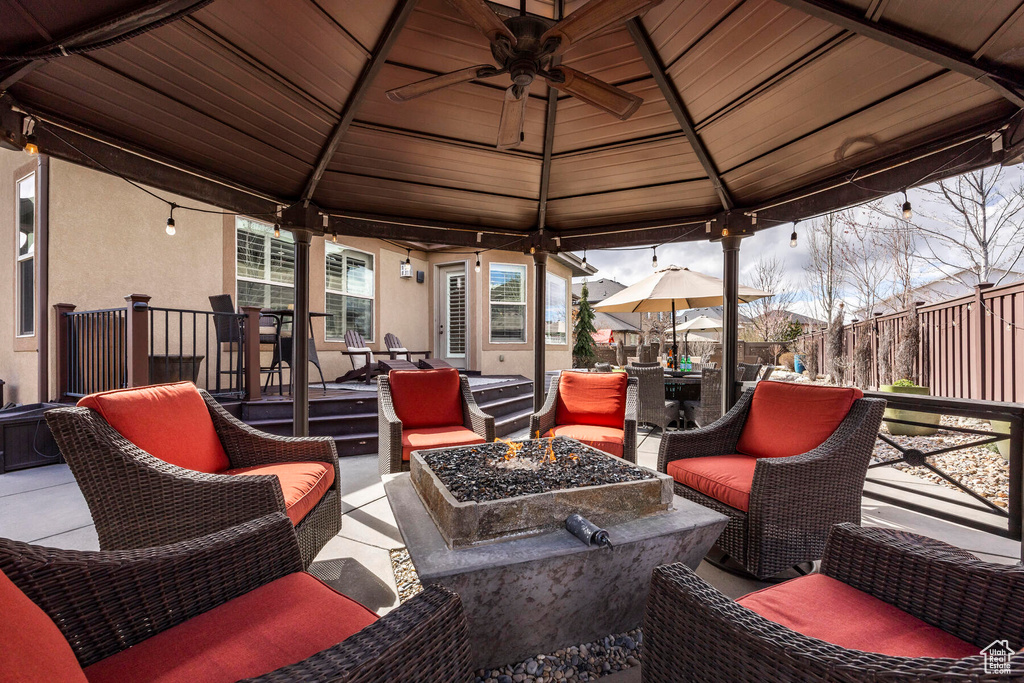 View of terrace featuring an outdoor living space with a fire pit, a gazebo, and ceiling fan