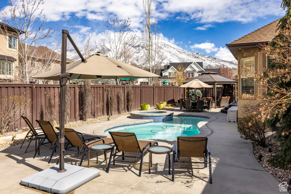 View of pool with a mountain view, an in ground hot tub, a gazebo, and a patio area