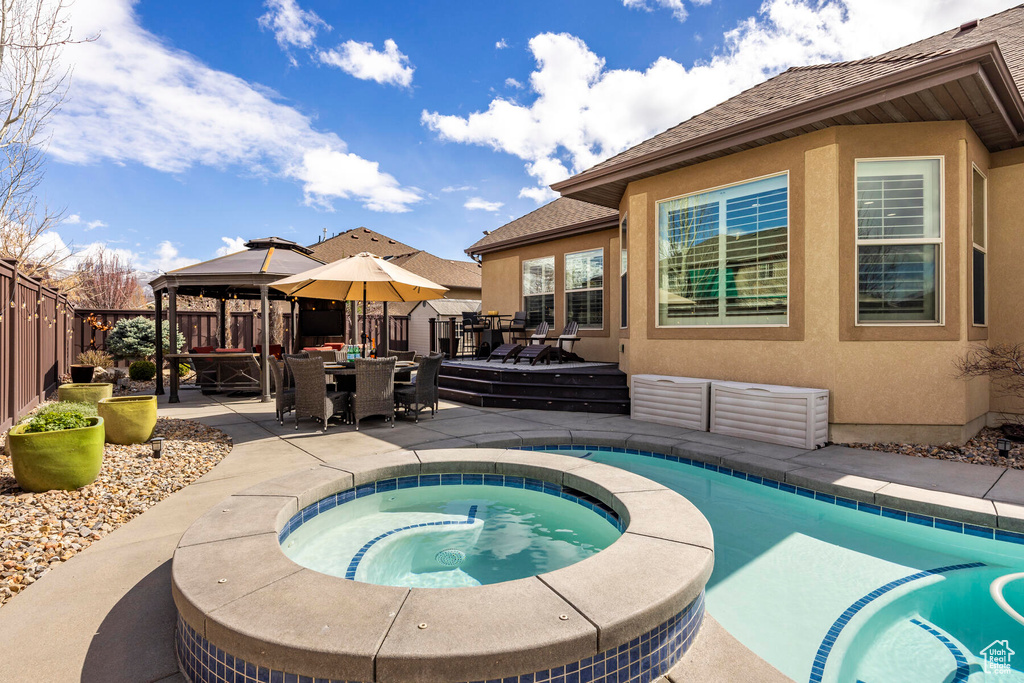 View of pool with a gazebo, an in ground hot tub, outdoor lounge area, and a wooden deck