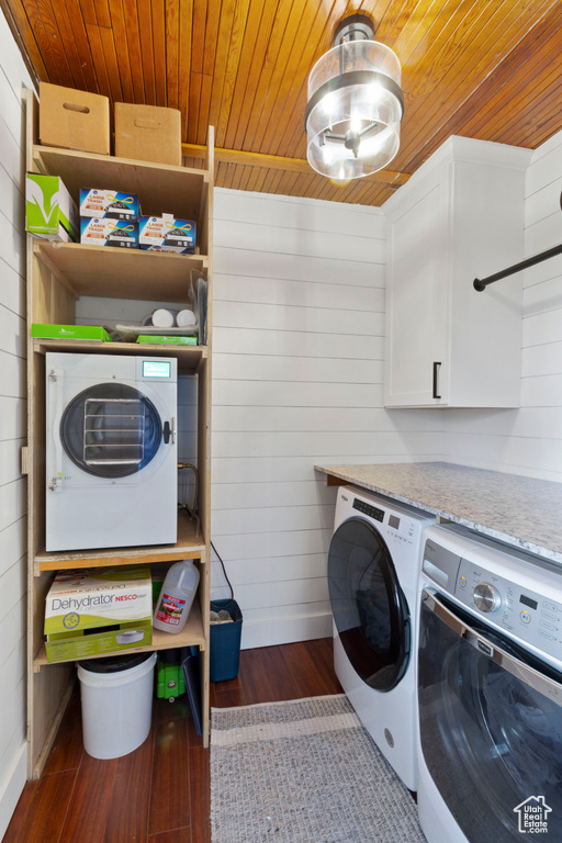 Laundry area with dark hardwood / wood-style flooring, wooden ceiling, cabinets, and washer and clothes dryer