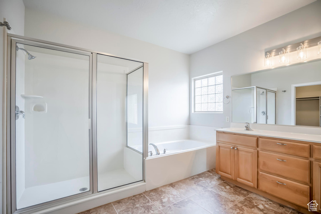 Bathroom featuring tile flooring, oversized vanity, and plus walk in shower