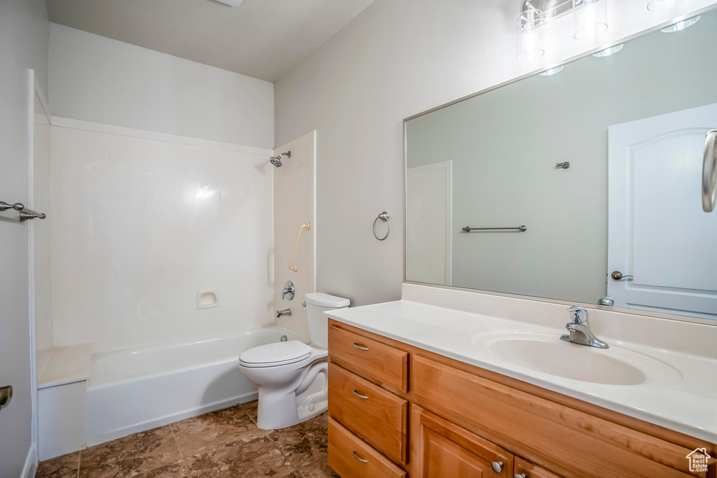 Full bathroom featuring shower / bath combination, vanity, toilet, and tile flooring
